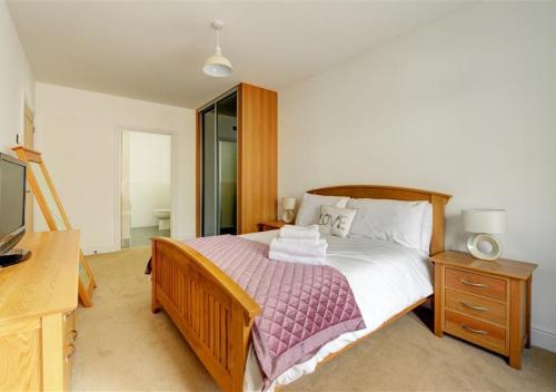 サンダースフットにあるThe Coach House Cambrian Quayのベッドルーム(ベッド1台、ドレッサー、テレビ付)