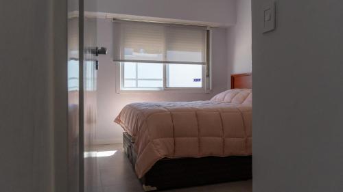 Schlafzimmer mit einem Bett und einem Fenster in der Unterkunft Departamentos por día - Bartolome.gralroca in General Roca