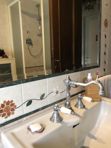 een wastafel in de badkamer met een spiegel en een douche bij CASA GIULIA in Pescara
