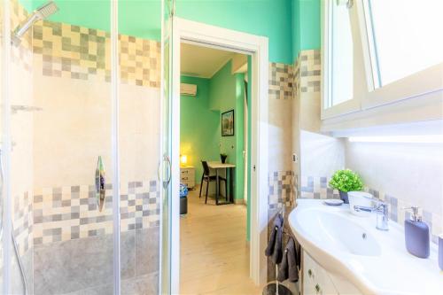 a bathroom with a shower and a white sink at Hostly - Art & Color Rome Midtown - 3BR 2BA in Rome