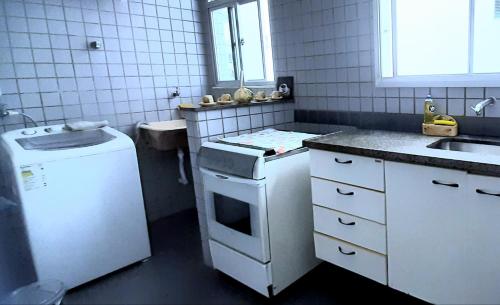 a small kitchen with a sink and a refrigerator at Lindo Ap Praia da Costa com Ar Condicionado in Vila Velha