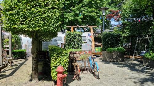 a red fire hydrant and a bike parked next to a tree at AirstreamNB in Schayk