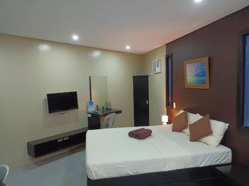 a bedroom with a bed and a television in it at Casita Isla Beach Inn in Boracay