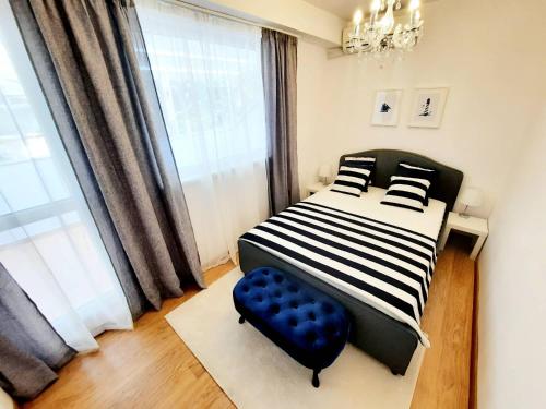 a bedroom with a bed and a blue chair at VARNA NAUTICAL Apartment in Varna City