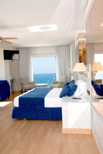 a bedroom with a large bed with a blue blanket at Playadulce in Aguadulce