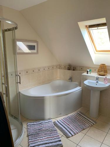 a bathroom with a large tub and a sink at Hen Pen in Montrose
