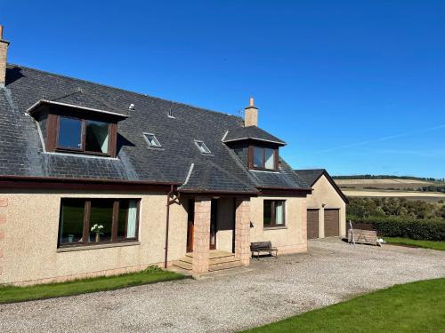a house with a black roof and a gravel driveway at Hen Pen in Montrose