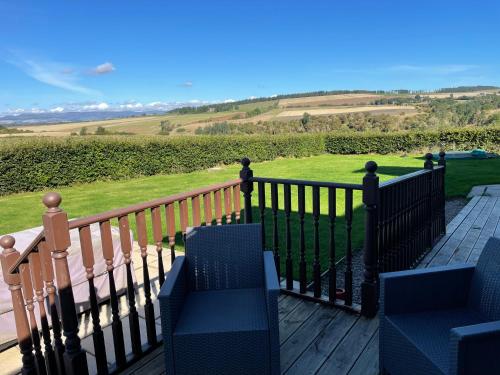 a deck with chairs and a fence with a view at Hen Pen in Montrose