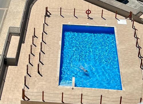 a person swimming in a large swimming pool at McRamé Design Apt Sea View, Beachfront, Swimming Pool, 2BDR, 2BAR, 6 pax, Praia da Rocha in Portimão