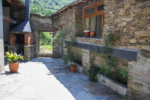 a stone house with potted plants on the side of it at Casa Xaupi 1 in Roní