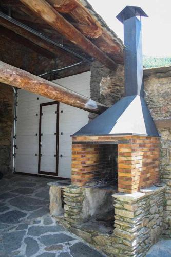 a brick fireplace in a building with a door at Casa Xaupi 1 in Roní