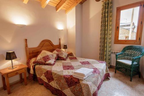 a bedroom with a bed and a chair and a window at Casa Xaupi 1 in Roní