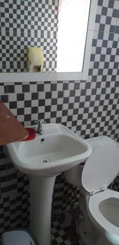 a bathroom with a white sink and a toilet at cabañas Te Pito Kura in Hanga Roa