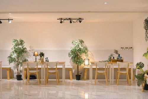 a dining room with tables and chairs and potted plants at Nap77 Salaya in Salaya