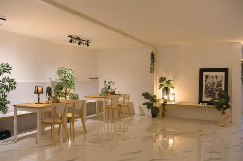 a dining room with tables and chairs and potted plants at Nap77 Salaya in Salaya
