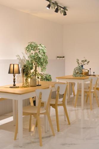 a room with tables and chairs with plants on them at Nap77 Salaya in Salaya