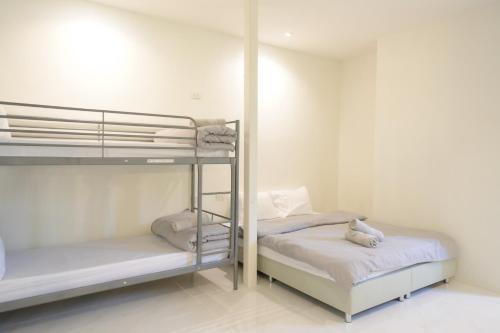 two bunk beds in a room with white walls at Nap77 Salaya in Salaya