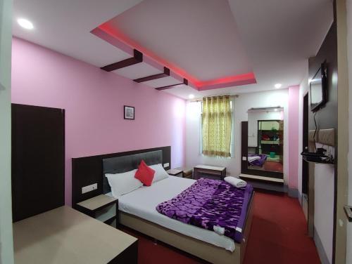 a bedroom with a large bed with purple sheets at Hotel La Casa in Namchi