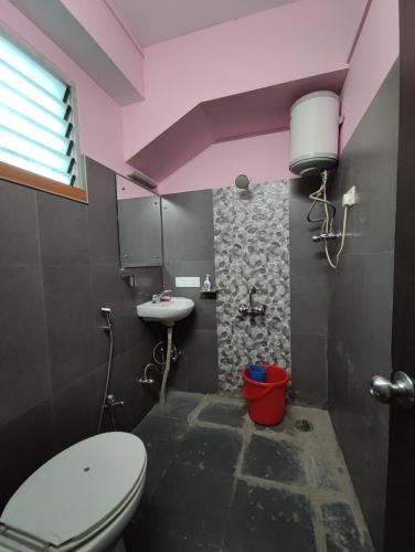 a bathroom with a toilet and a sink at Hotel La Casa in Namchi