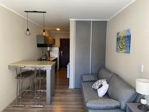 sala de estar con sofá y cocina en Casa De Playa Dpto Con Pileta Climatizada A 50 M Del Mar en Necochea