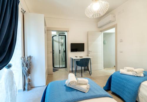 a bedroom with two beds and a table with a desk at SAN BARTOLOMEO BAROQUE in Scicli