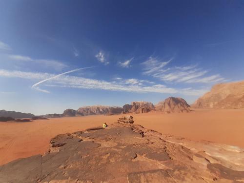 ワディ・ラムにあるMad Mix campの砂漠の岩の上に座っている人々のグループ