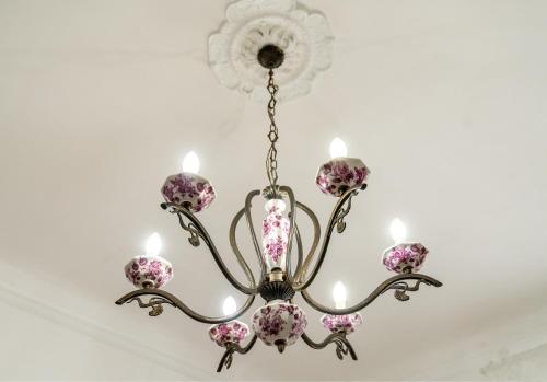 a chandelier with pink flowers hanging from a ceiling at SAN BARTOLOMEO BAROQUE in Scicli
