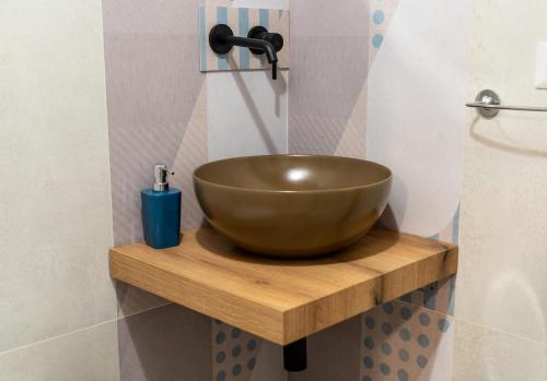 a bathroom with a bowl sink on a wooden shelf at SAN BARTOLOMEO BAROQUE in Scicli