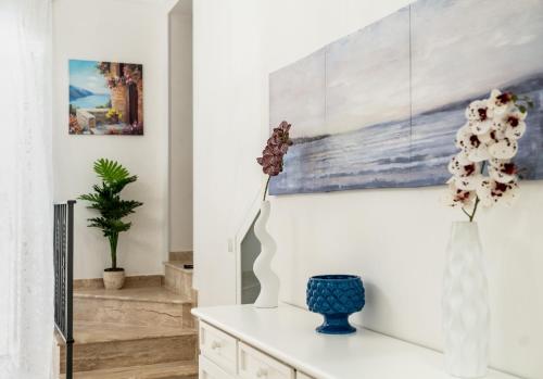 a living room with a vase and a painting on the wall at SAN BARTOLOMEO BAROQUE in Scicli