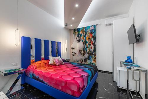 un letto colorato in una stanza con un dipinto sul muro di Prezioso suites & rooms a Lecce