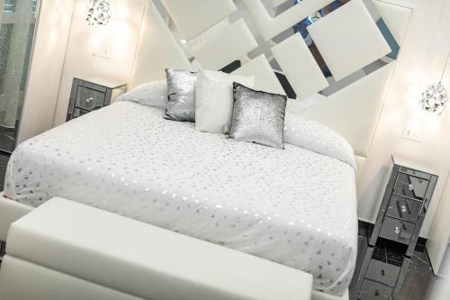 a white bedroom with a white bed with pillows at Prezioso suites & rooms in Lecce