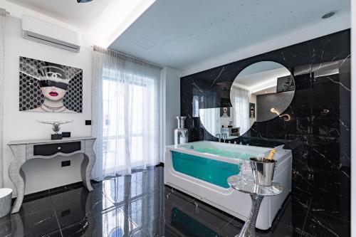 a bathroom with a tub and a mirror at Prezioso suites & rooms in Lecce