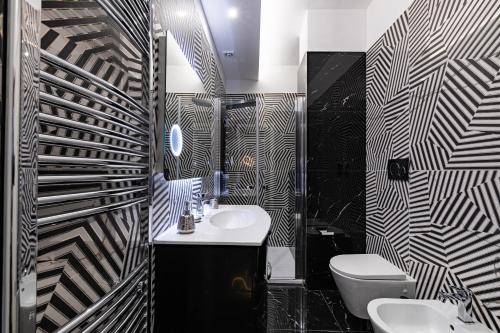 a black and white bathroom with a sink and a toilet at Prezioso suites & rooms in Lecce