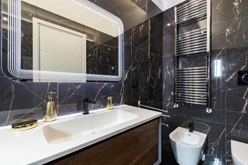 a bathroom with a white sink and a mirror at Prezioso suites & rooms in Lecce