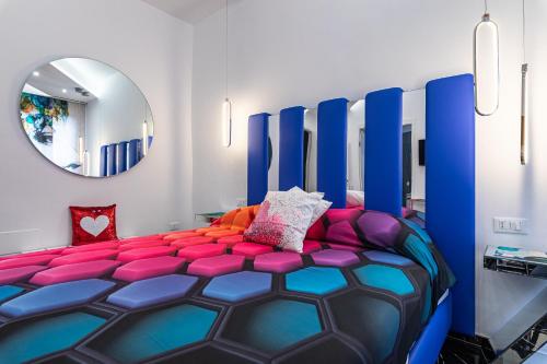 a bedroom with a blue and pink bed with a mirror at Prezioso suites & rooms in Lecce
