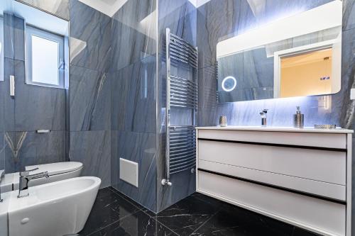 a bathroom with a sink and a toilet and a mirror at Prezioso suites & rooms in Lecce