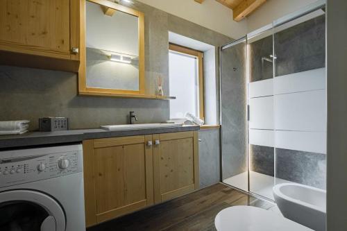 La salle de bains est pourvue d'un lavabo et d'un lave-linge. dans l'établissement Appartamento Césa Ines, à Arabba