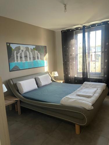 Cette chambre comprend un grand lit et une fenêtre. dans l'établissement Villa Atlantique Rochefort, à Rochefort