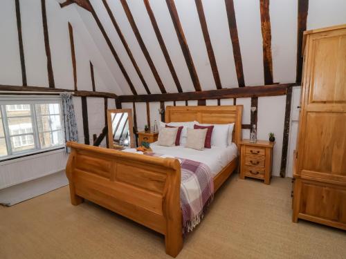 a bedroom with a bed with a wooden bed frame at Lavender Cottage, Aldeburgh in Aldeburgh
