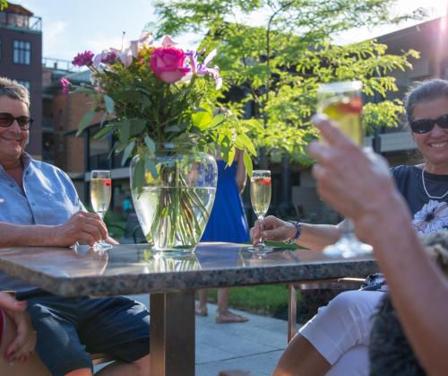 un gruppo di persone seduti a un tavolo con bicchieri di vino di Hotel Montfort Nicolet a Nicolet