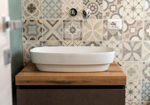 a white sink on a wooden counter in a bathroom at SAN BARTOLOMEO BAROQUE in Scicli