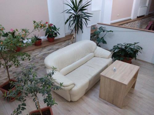 a living room with a white couch and a coffee table at Pensiunea Casa Rusu in Baia Mare