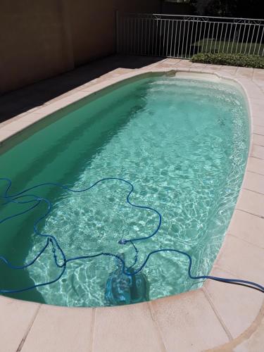 une piscine avec un tuyau dans l'eau dans l'établissement Maison les pins, à Vedène