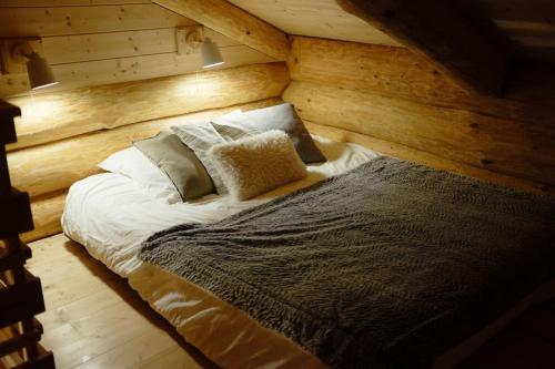 a large bed in a room with wooden walls at L'ermitage des vallons in Sulniac