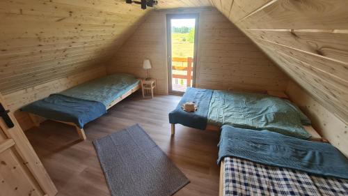 una camera con 2 letti in una baita di tronchi di Ostoja Ldzań 