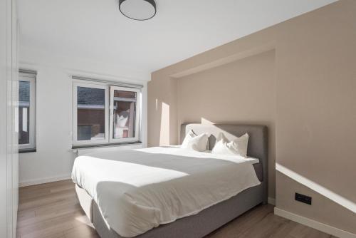 1 dormitorio con 1 cama grande con sábanas y almohadas blancas en Lappertemento en Willebroek