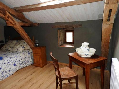a bedroom with a bed and a table with a vase on it at Propriete de 3 chambres avec jardin amenage et wifi a Nueil les Aubiers in Nueil-sous-les-Aubiers