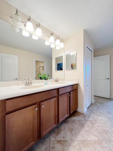 a bathroom with a sink and a large mirror at DWS Vacation Villas in Orlando