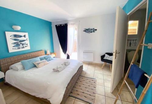 La villa Ty Mor Braz في Plouarzel: غرفة نوم بسرير كبير بجدران زرقاء