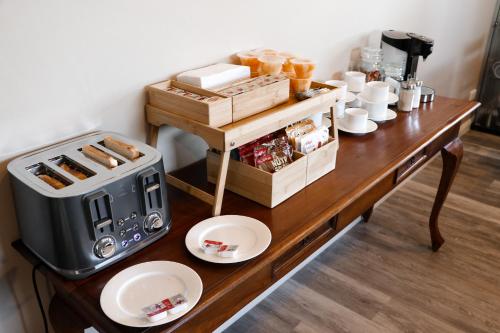 a table with a coffee maker and plates on it at Barnville@Bremer Bed & Breakfast in Bremer Bay